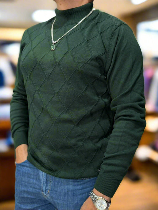 Person wearing a green quilted sweater with a blurred indoor background