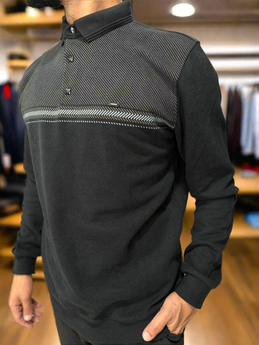 Man wearing a black and gray long-sleeve shirt with a patterned design in a clothing store.