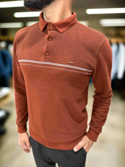 Man wearing a brown long-sleeve polo shirt with a blurred indoor background