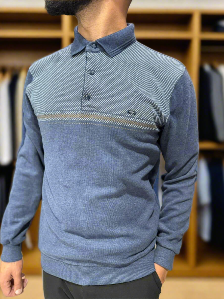 Person wearing a blue sweater with a collar in a clothing store.